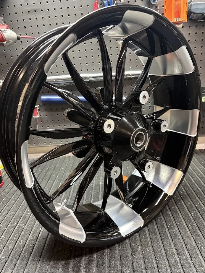 A Havoc Special 18x5.5 fat front wheel in gloss black with machined accents and an Enforcer-style hub. The wide rim carries a 180mm front tire.
